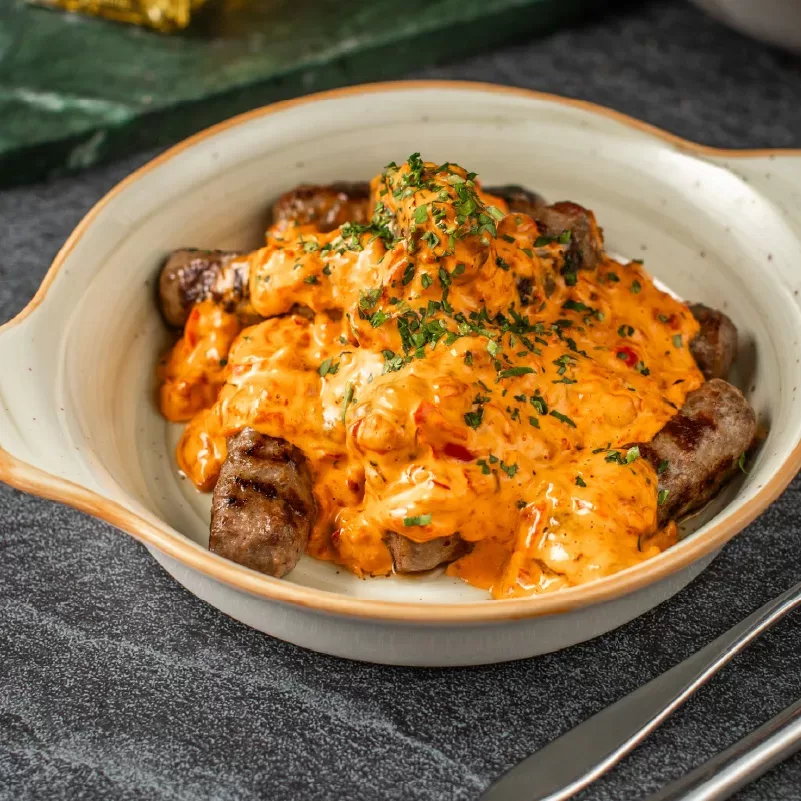 Ćevapi in a cream sauce of roasted peppers